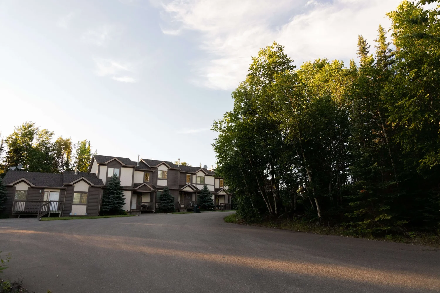 A row of modern townhouses with multiple storeys along a quiet street