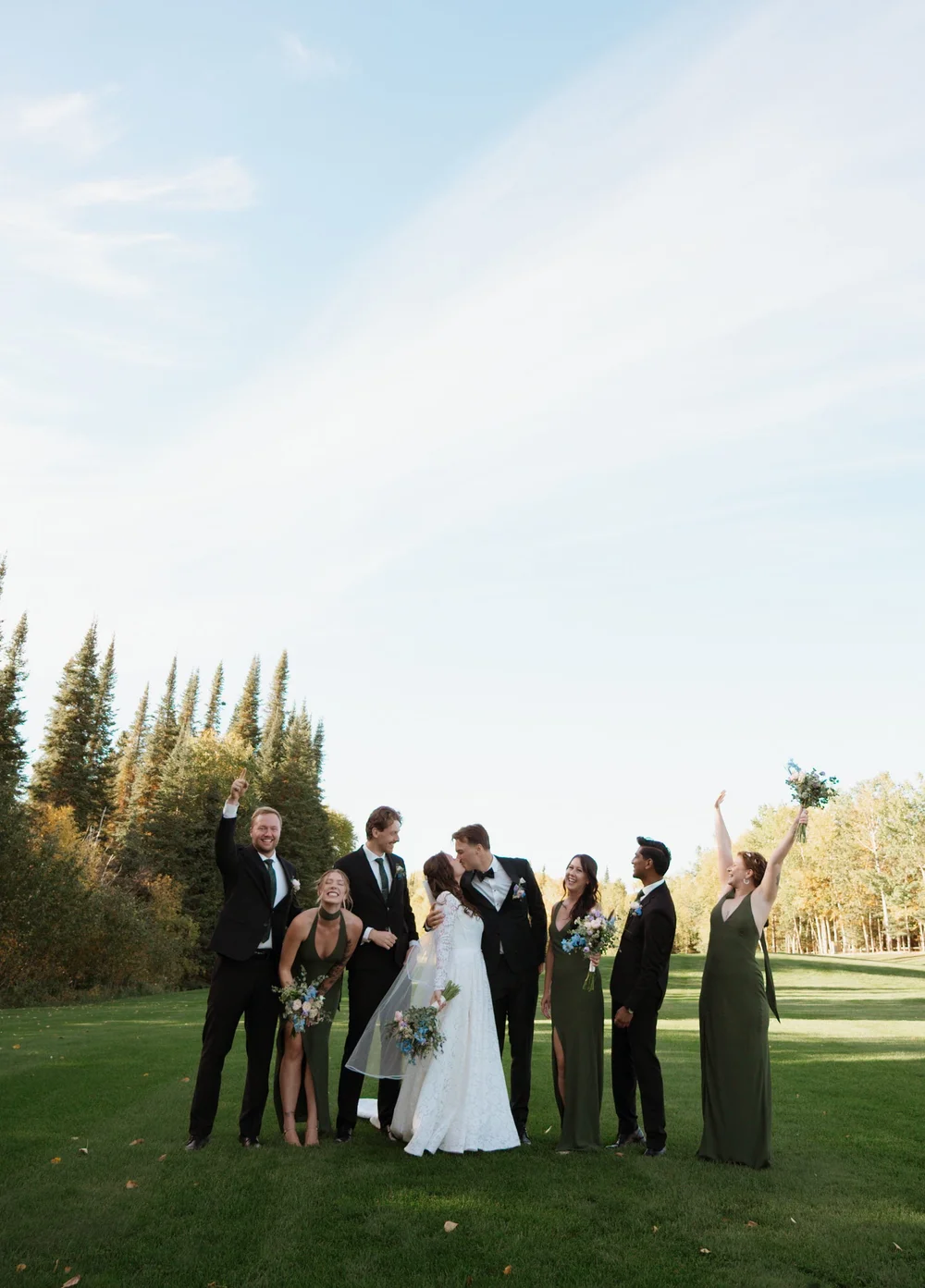 A group of wedding guests celebrating outdoors on the lawn