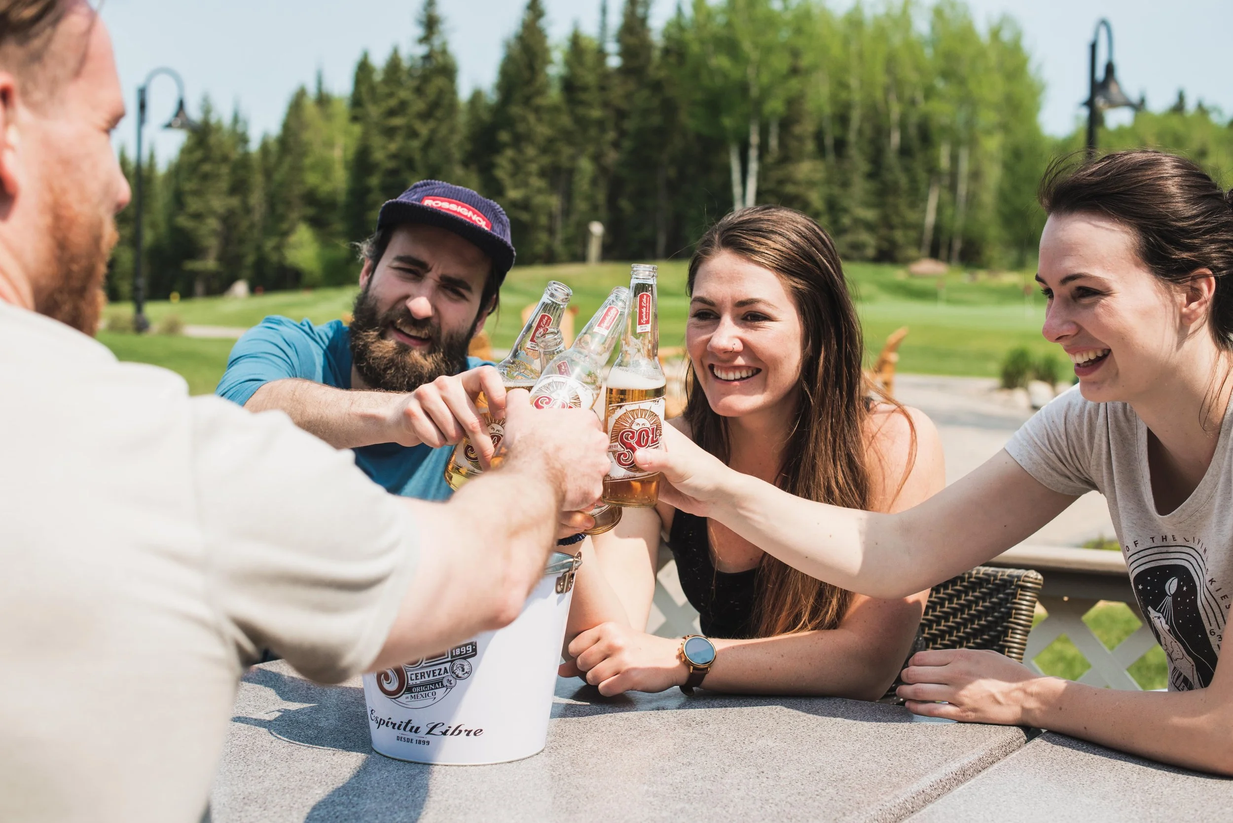 Group of friends outdoors clinking beer glasses together