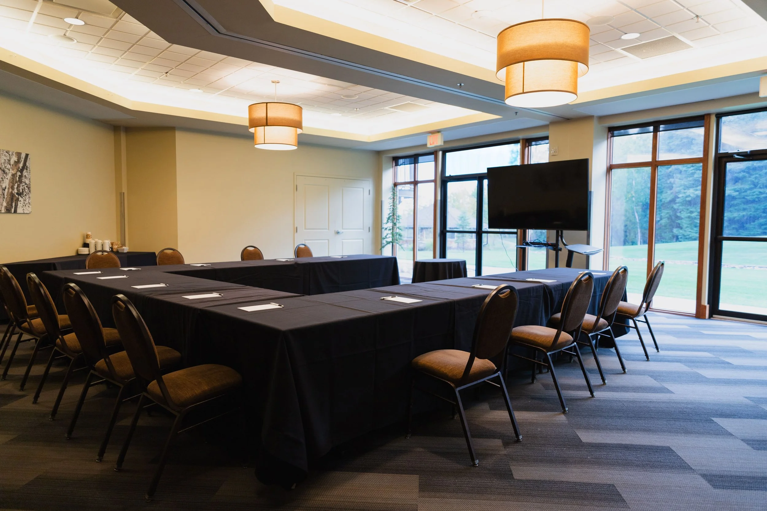 An empty conference room with black tables and chairs