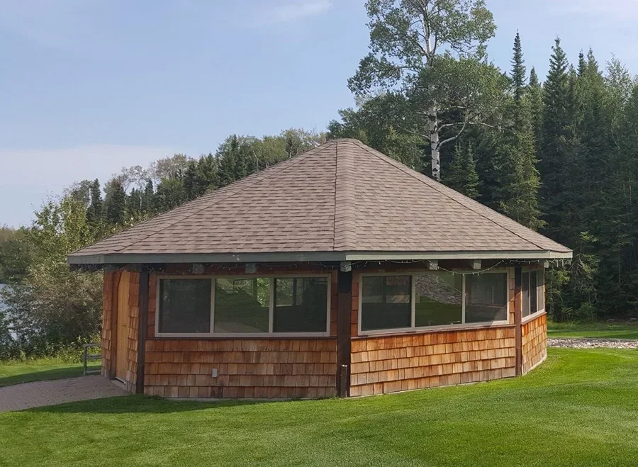 A round house with a shingled roof and curved walls