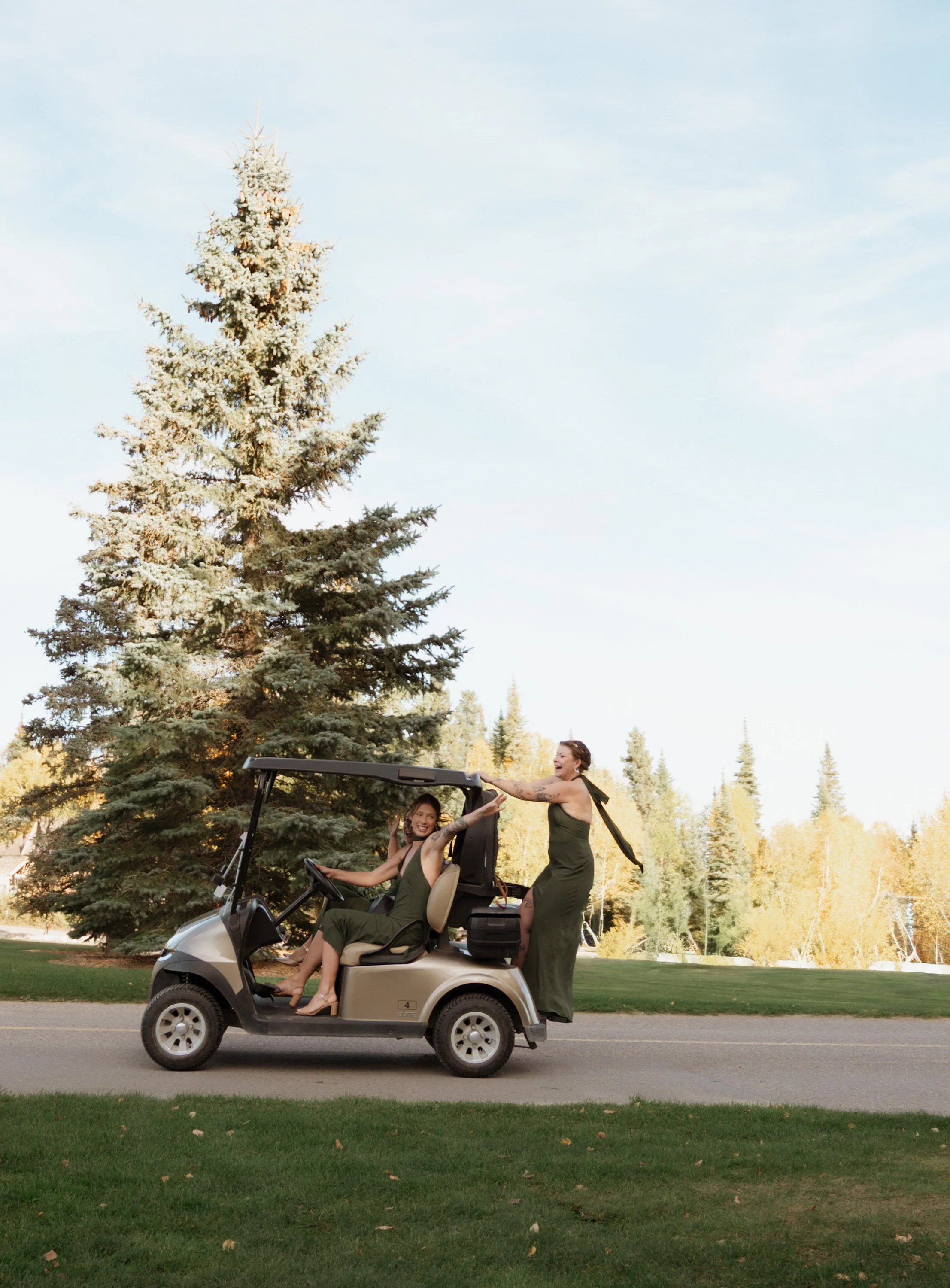 Two women riding in a golf cart on a golf course