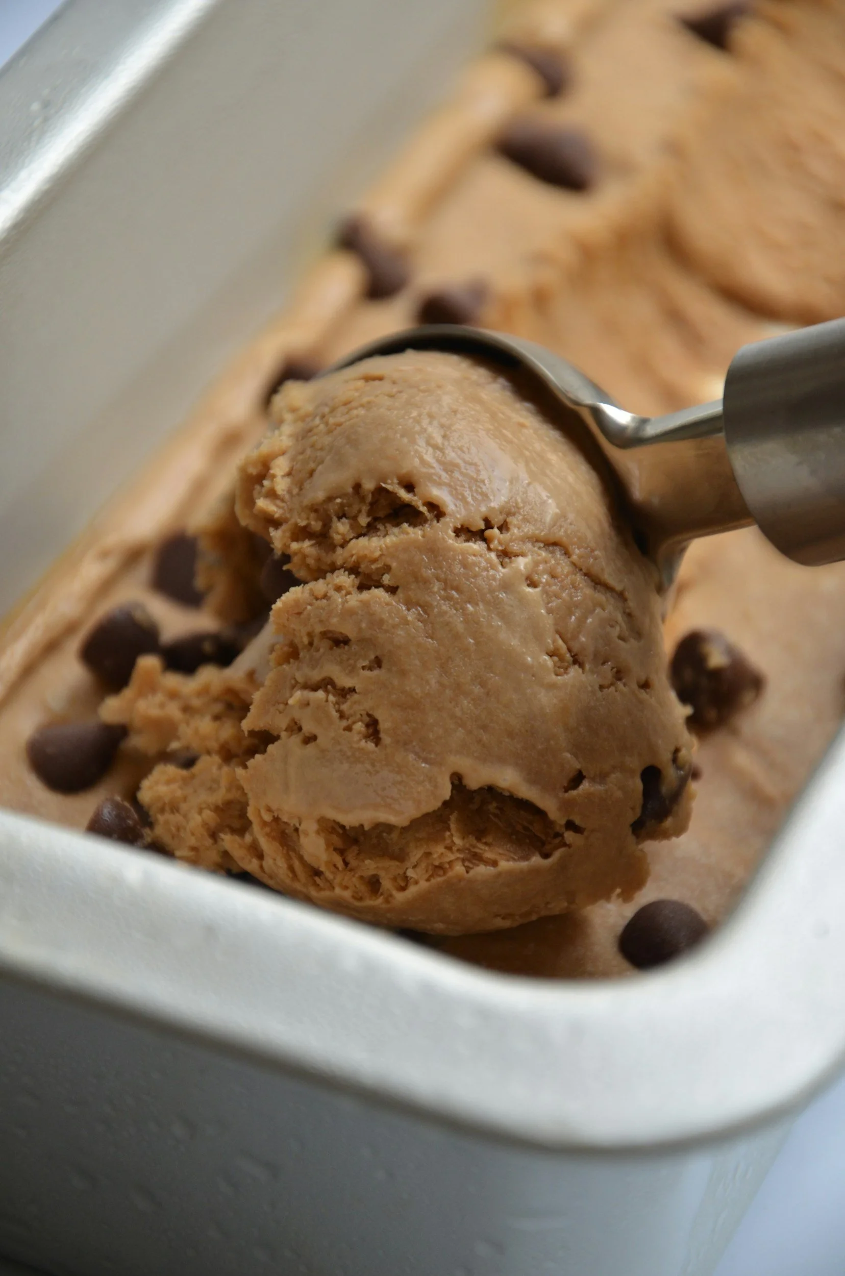 Close-up of a container with a scoop of chocolate chip cookie dough ice cream.