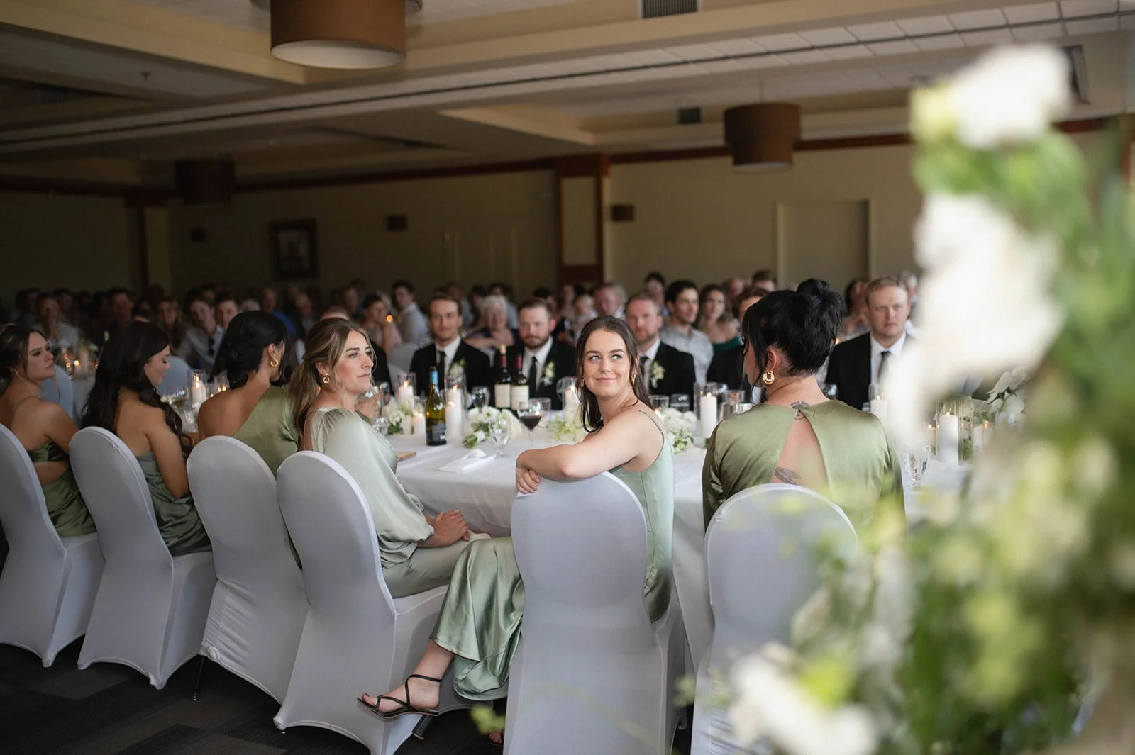 A group of people sitting at a formal event or banquet in a large room.