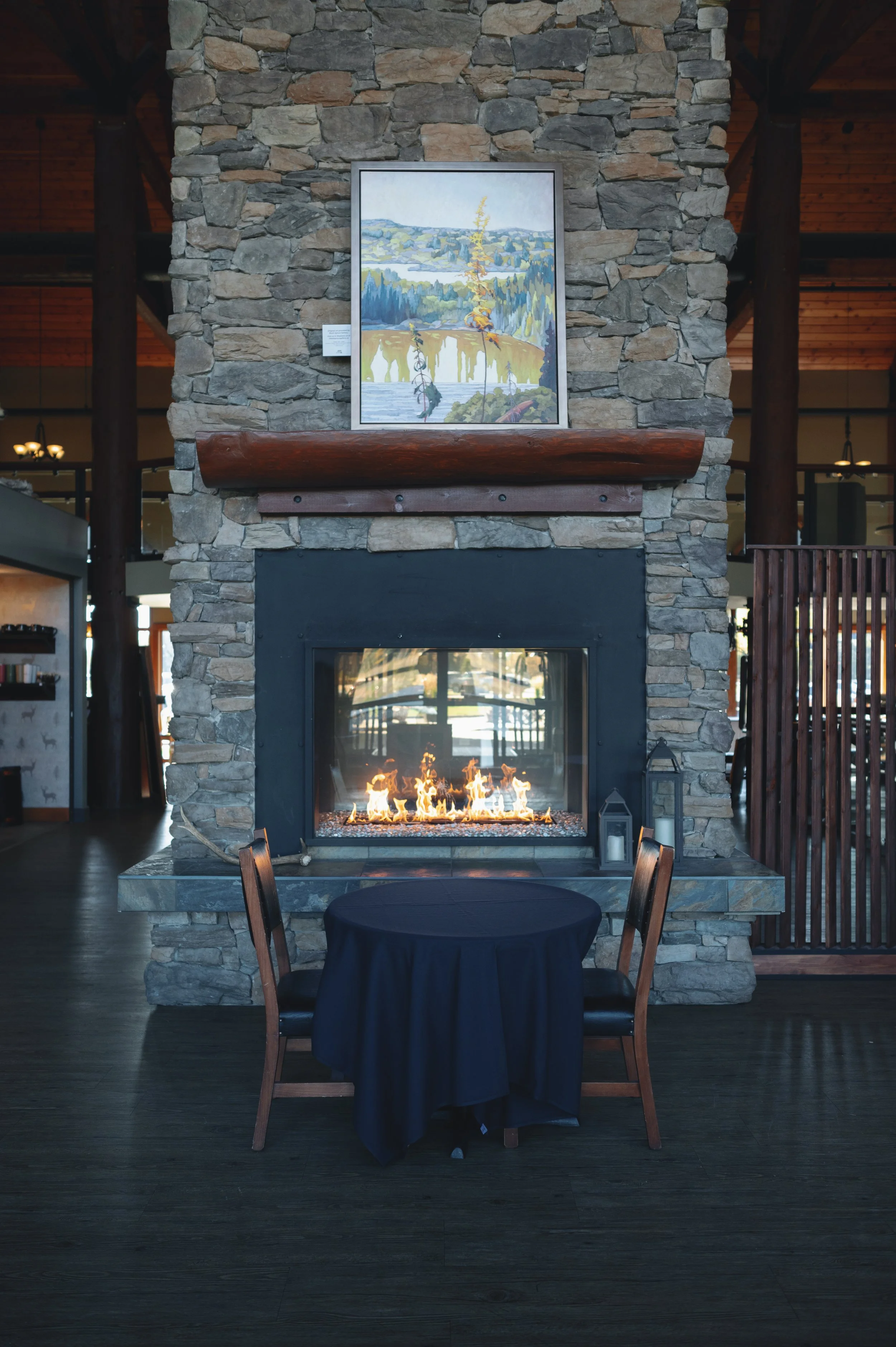A table for two set in front of the stone fireplace in the Lodge