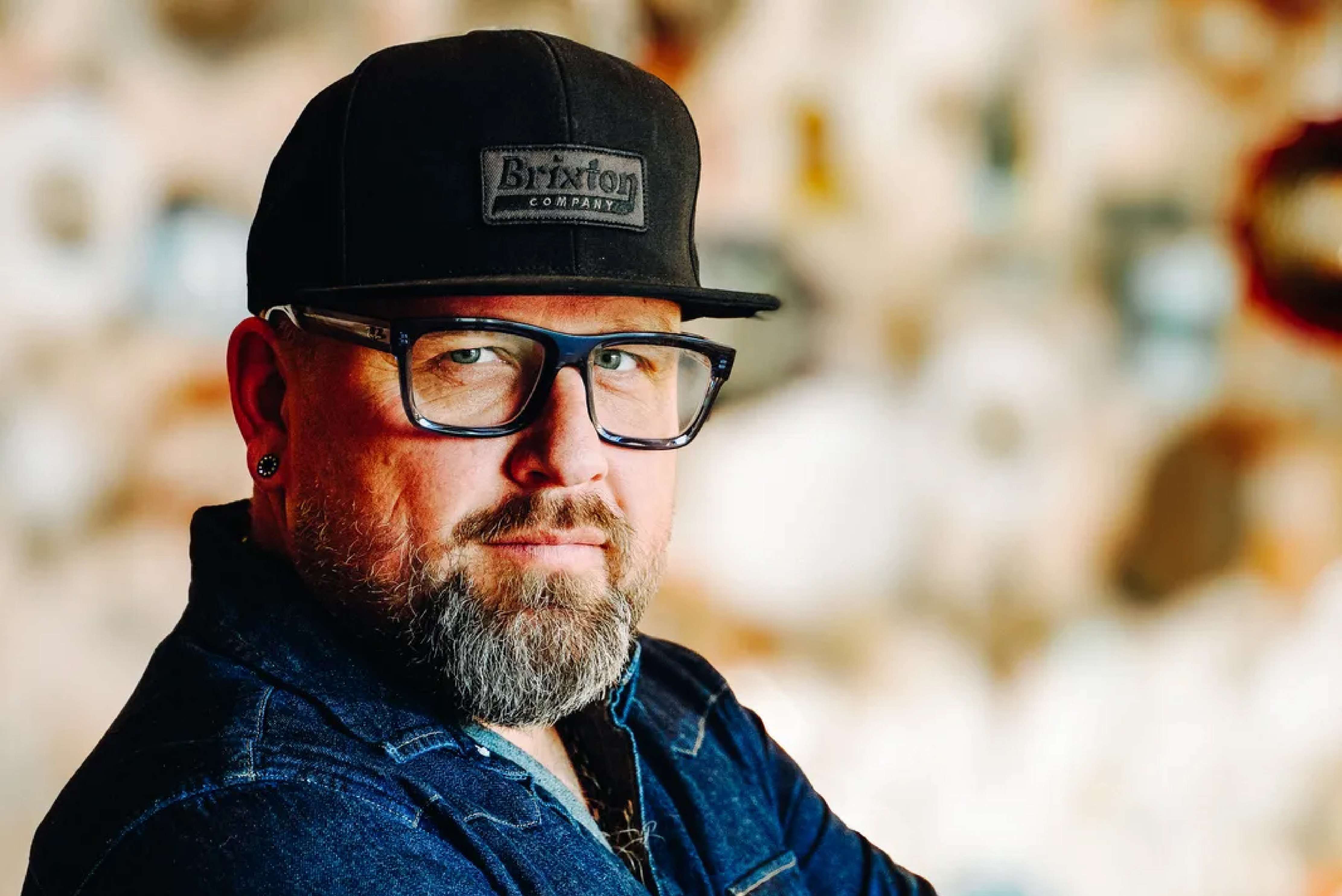 Darryl Anderson in a cap and denim shirt, arms folded