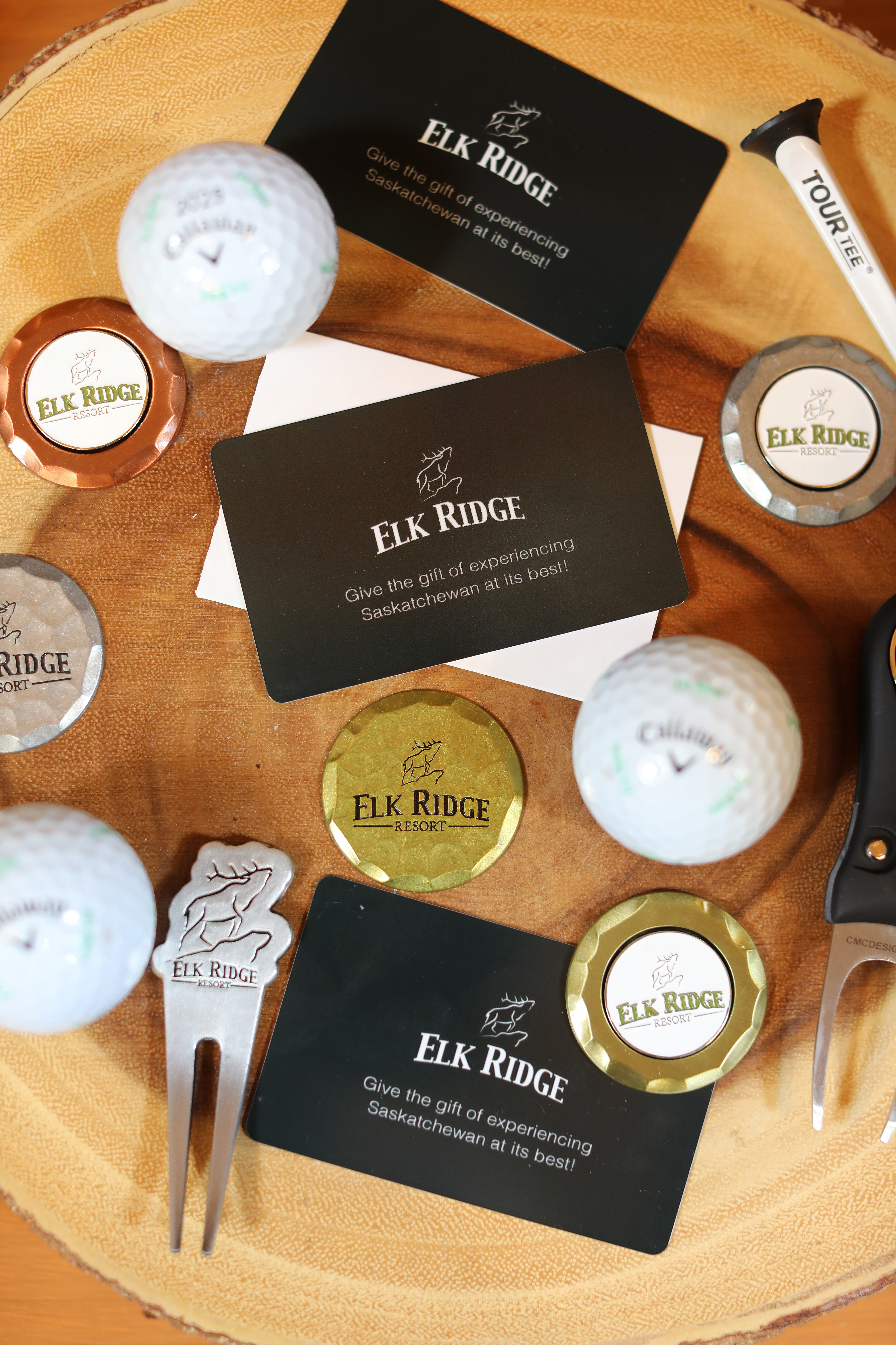 Elk Ridge Resort gift cards, golf balls and ball markers on a wooden round